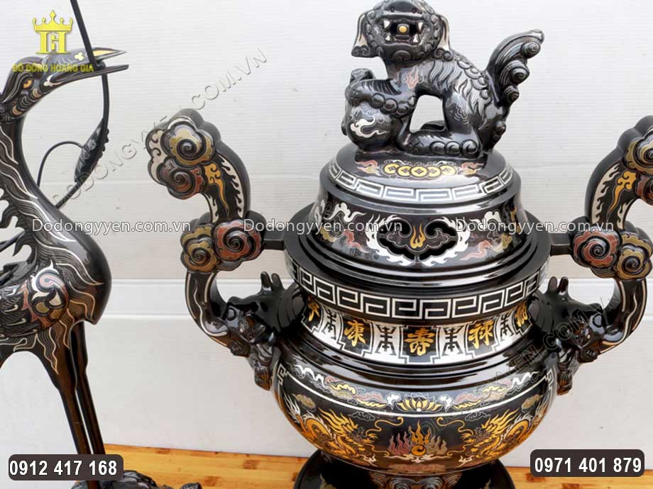 Đ&ocirc;i hạc đứng tr&ecirc;n lưng r&ugrave;a được đặt đối xứng hai b&ecirc;n, trầu v&agrave;o đỉnh đồng